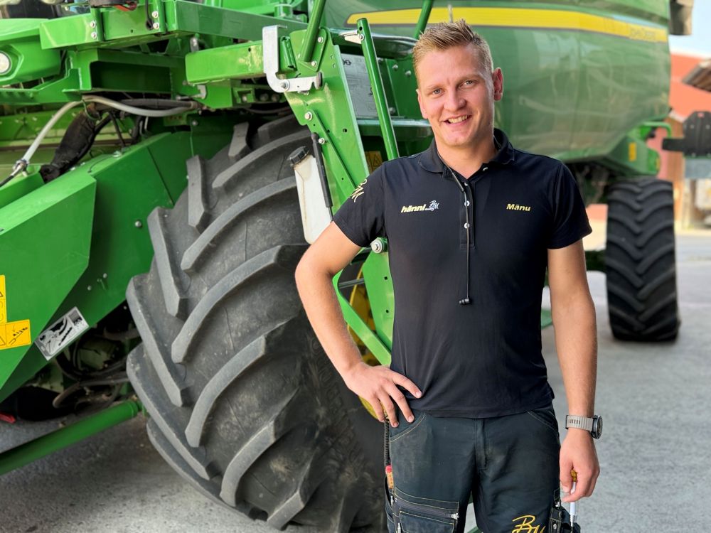 Manuel Hänni steht vor einem seiner John Deere Mähdrescher