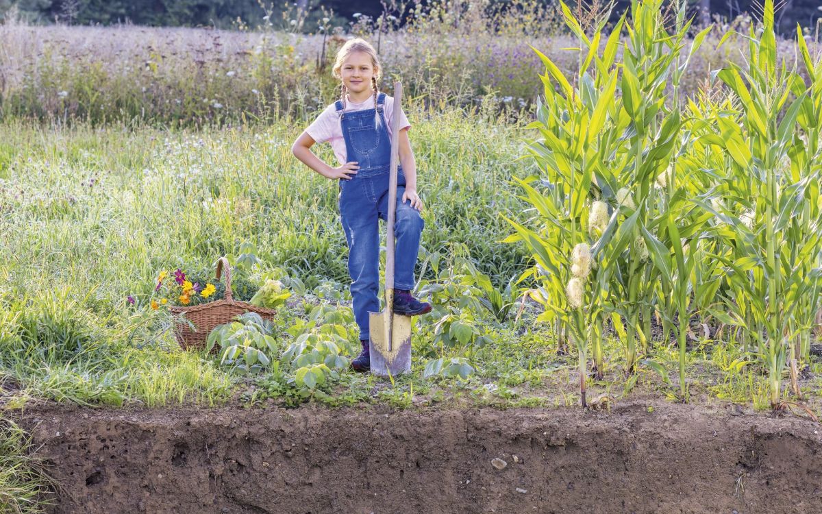 Emma avec une bêche et un profil pédologique