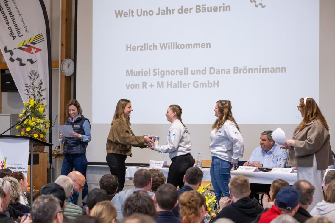 Muriel (2. v. r.) und Dana (3. v. r.) sind mit echter Leidenschaft auf den Feldern unterwegs. Lara Reusser (2. v. li.) übergibt den beiden eine Palette Drinks fürs Team. (Bild: Raphael Hünerfauth)
