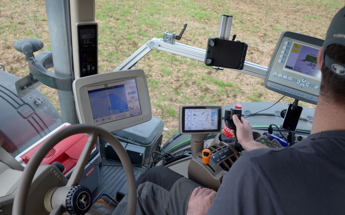 Dans la cabine du tracteur, une personne utilise un écran